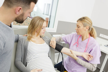 nurse checking blood pressure of a pregnant woman