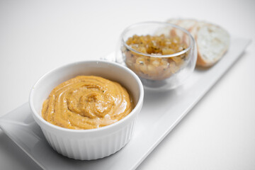 close up of goose liver pate with apple chutneys and bread on white background