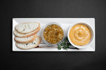 top view of goose liver pate with apple chutneys and bread on black background - obrazy, fototapety, plakaty