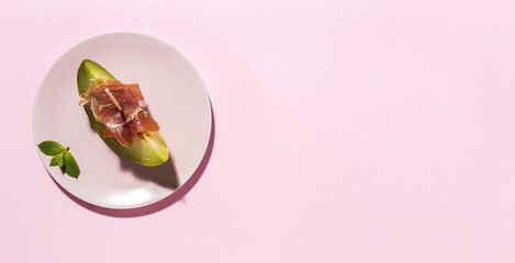 Sliced fresh melon with ham with sunlight on colorful backgrounds