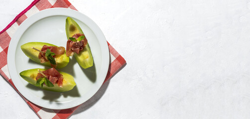 Sliced fresh melon with ham with sunlight on colorful backgrounds