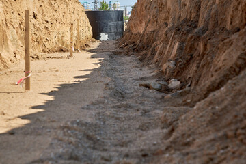 Trench for laying water pipes, with a concrete well covered with waterproofing mastic