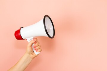 Woman holding megaphone on pink background