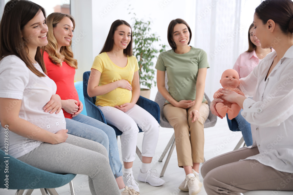 Sticker group of pregnant women with midwife at courses for expectant mothers indoors