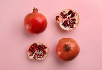 Flat lay composition with ripe pomegranates on pink background