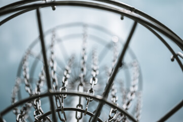Underneath a disc golf goal looking up with selective focus on the chain basket.