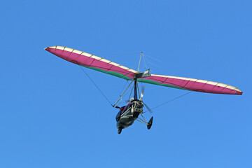 	
Ultralight airplane flying in a blue sky	