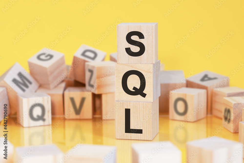 Poster wooden cubes with letters sql arranged in a vertical pyramid, yellow background