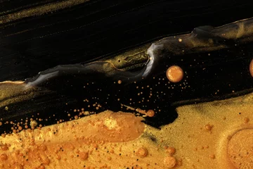 Abstrakter Gold- und Bronzefleck und -tropfen auf schwarzem horizontalem Hintergrund. Marmorstruktur. Acrylfarbe in Wasser und Öl. © Liliia