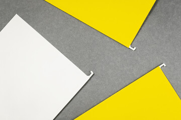 White and yellow hanging files lay flat on gray background. Banner with copy space and mockups for text. Office supplies or notice