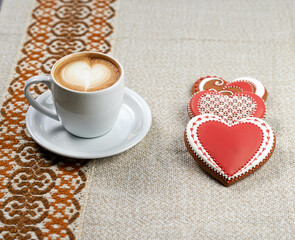 Cookie heart. Cropped closeup of a coffee table with cookies and Valentine’s day cup of coffee