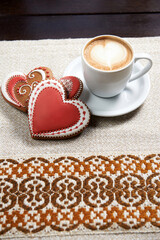 For the loved one. Shot of a cup of coffee with cookies for Valentine’s day on the table in a coffee shop