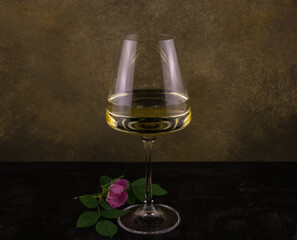 a glass of white wine with a wild rose