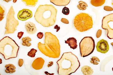 Close up of dried strawberry,almonds, dried apricot, raisins, walnuts, dried apples and kiwi on white background. Concept of organic healthy assorted dried fruit for snacks.