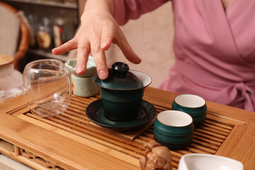 Fototapeta na wymiar Master conducting traditional tea ceremony at table, closeup