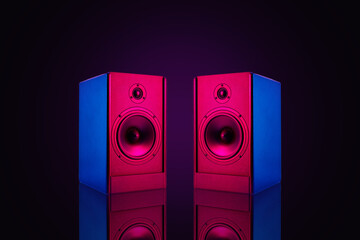 Two neon colored stereo speakers on dark background with reflection.Sound audio loud speakers,...