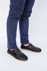 A man is wearing classic black shoes made of natural leather on lace, shoes for men under business style