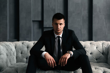 Handsome businessman on sofa indoors. Luxury lifestyle - obrazy, fototapety, plakaty