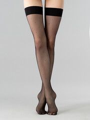 black stockings with polka dots on a gray background