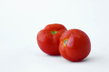 red tomatoes with water drops, two tomatoes, tomatoes on a white background