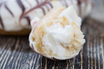 a fresh doughnut covered with white chocolate , closeup