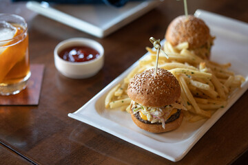 Mini burgers and french fries on a plate at a restaurant