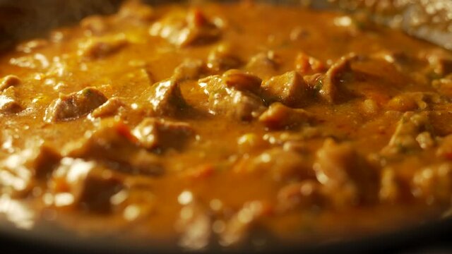 Close up of stewing beef and vegetables goulash in a pan. Concept of cooking tasty food.