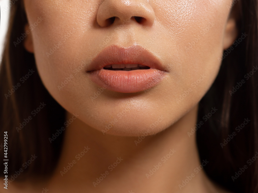 Wall mural close-up of woman's lips with fashion natural beige lipstick makeup. macro sexy pale lipgloss make-u