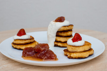 Delicious homemade pancakes with strawberries on plate on a light background