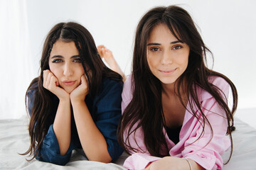 smiling armenian women looking at camera near bored friend