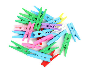 Pile of colorful wooden clothespins on white background, top view