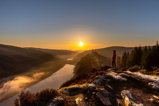 A male standing on the Spink Viewing Spot admiring the sunrise