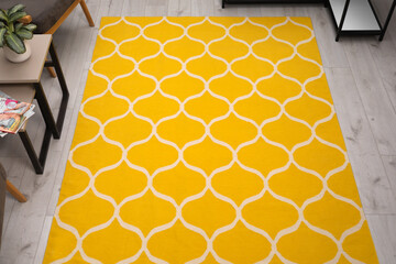 Stylish yellow carpet with pattern on floor in living room, above view