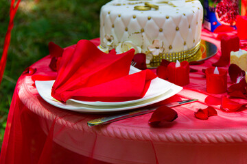 Autumn evening photo shoot - romantic dinner outdoors. Table with tablecloth and decoration - pie, figs, glasses,  table and candle.