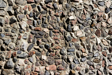 Texture photo of old small sized stone and concrete wall backdrop.