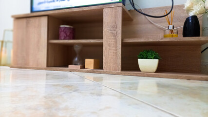 Fototapeta na wymiar macro focused wooden tv stand with floor closeup,home decor idea