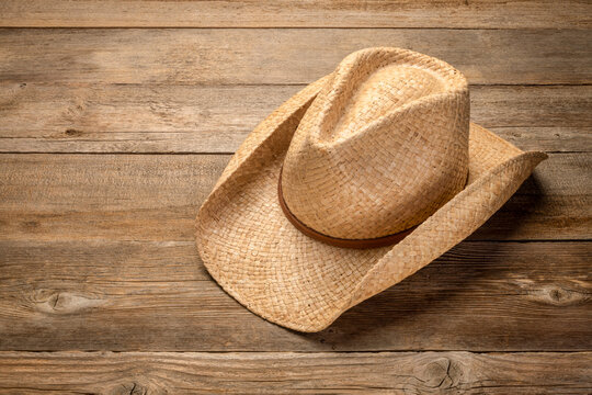 ranch style, cowboy straw hat  on rustic wooden table