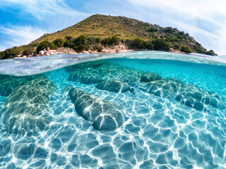 Fototapeta premium Amazing blue and transparent sea water in half underwater effect. Fascinating combination of land and sea.