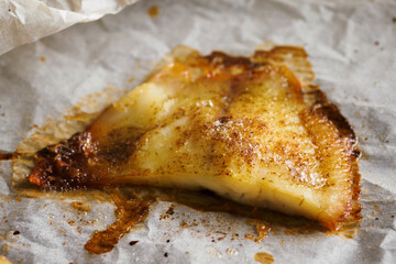 Fish fillet fried in butter on baking paper.