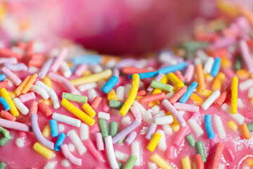Fototapeta na wymiar Donut Fully Close-up With Pink Icing And Colored Sprinkles. Side view.