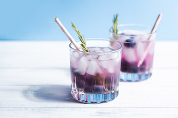 Chilled water with ice and blueberries in a glass with a cocktail tube. Summer refreshing cocktails...