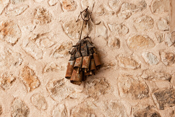 Rusty cowbells for Cattle hanging on a stone wall