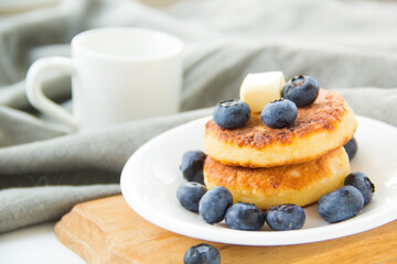 A healthy breakfast of pancakes, berries, butter, and honey. Creative atmospheric decoration