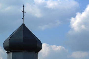 Fototapeta na wymiar Dome of orthodox church and cross and the clouds on the blue sky. Christianity religion background