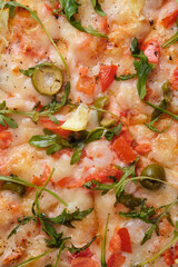 Pizza with tomatoes, shrimps, arugula, olives, lemon, mozzarella cheese, spices and tomato sauce. A...