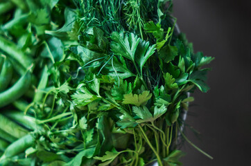 Fresh herbs and spices fresh cuts for cooking in a bowl.  Green peas, dill, and parsley close up