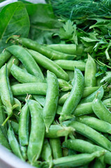 Fresh green peas for cooking in a peel in a bowl