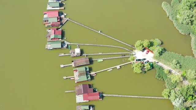 Aerial view of the famous Bokod Floating Village with piers and traditional wooden fishing cottages built on the lake Bokodi. Walkboards leading to small fishing houses floating on water in Oroszl&aacute;ny