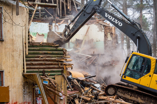 Demolition of an old wooden log house with a Volvo excavator: Kaluzhskiy region, Russia - April 2021
