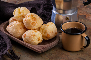 table with delicious cheese breads, a coffee mug and a traditional coffee maker - Powered by Adobe